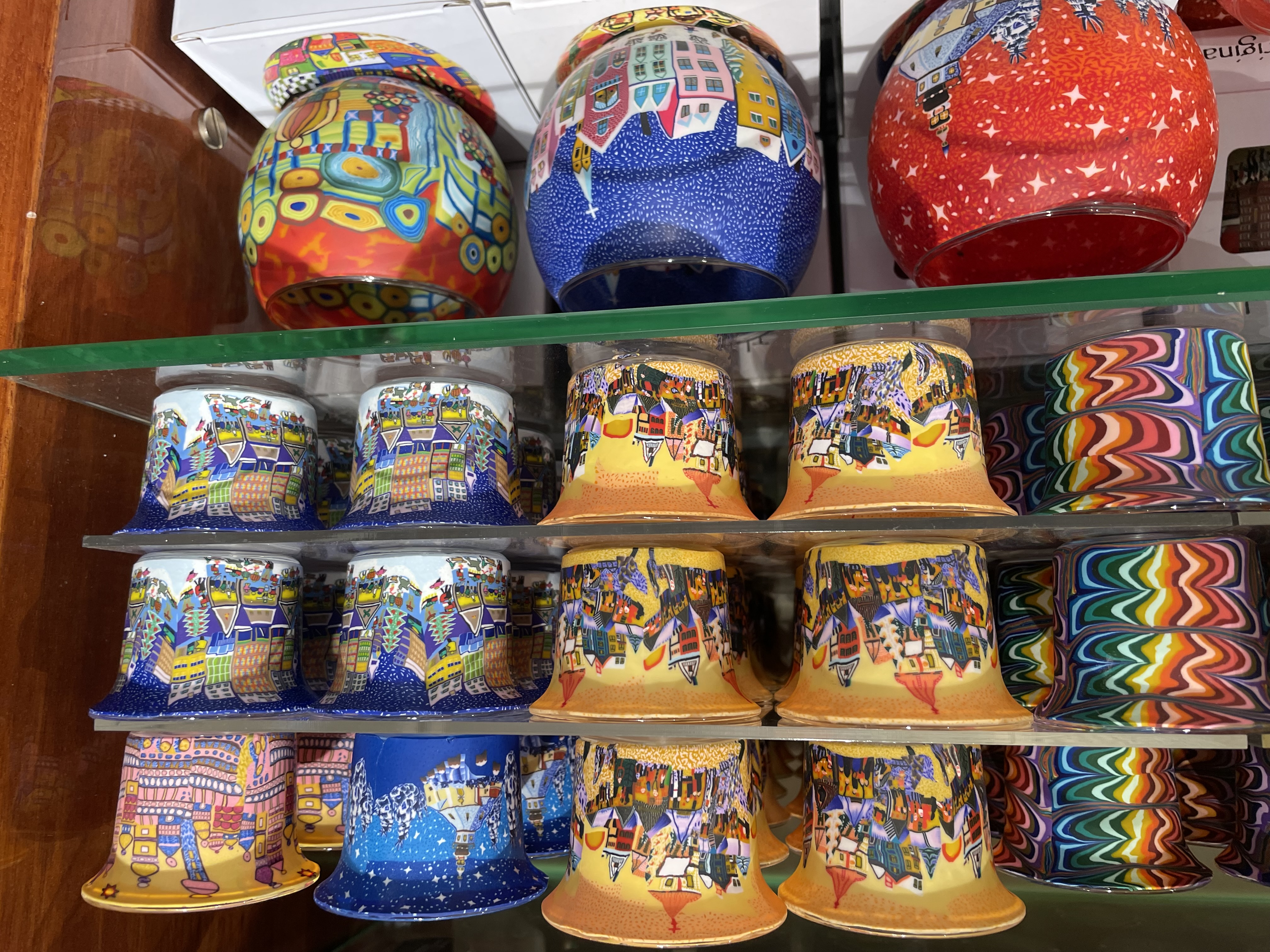Rows of colourful ceramic mugs on shelves
